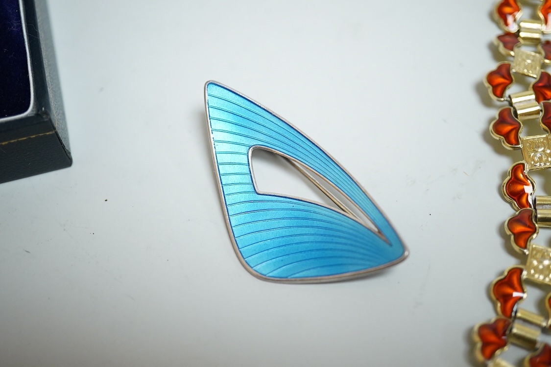 A pair of Norwegian gilt sterling and blue enamel ear clips by David Andersen, 31mm, together with one other Norwegian 925S and blue enamel free form brooch, 47mm and a gilt 925S and red enamel set necklace, 39.5cm.